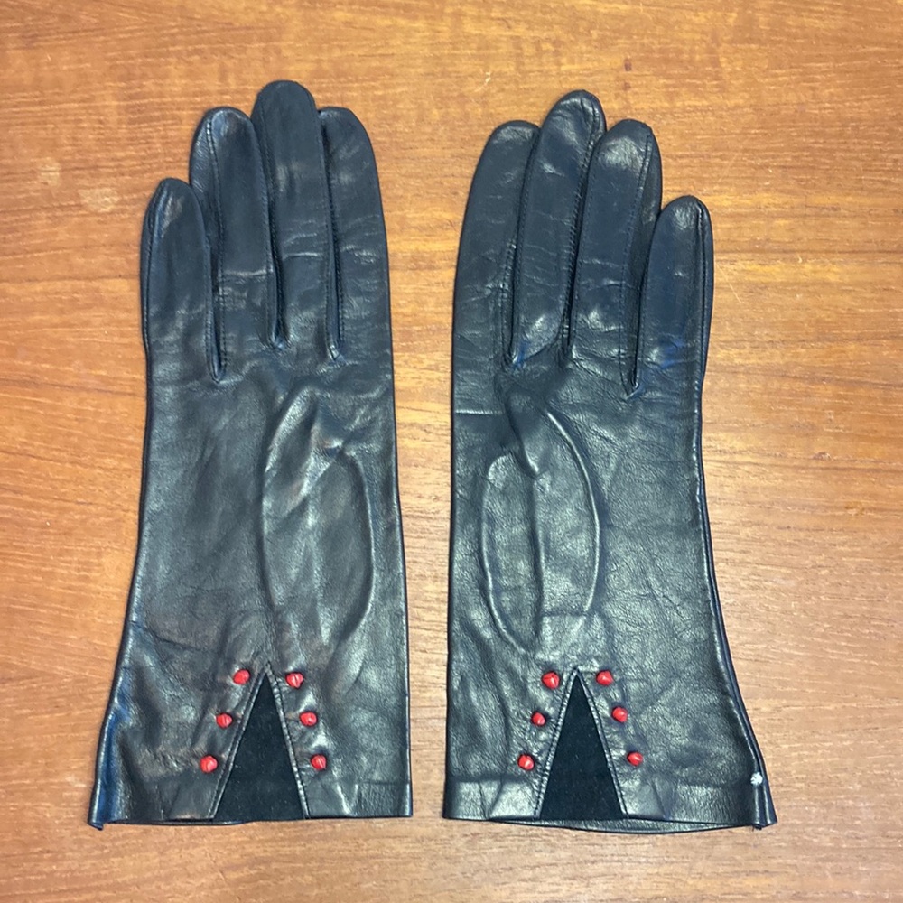 Vintage ladies black leather gloves with red knot and suede triangle details.